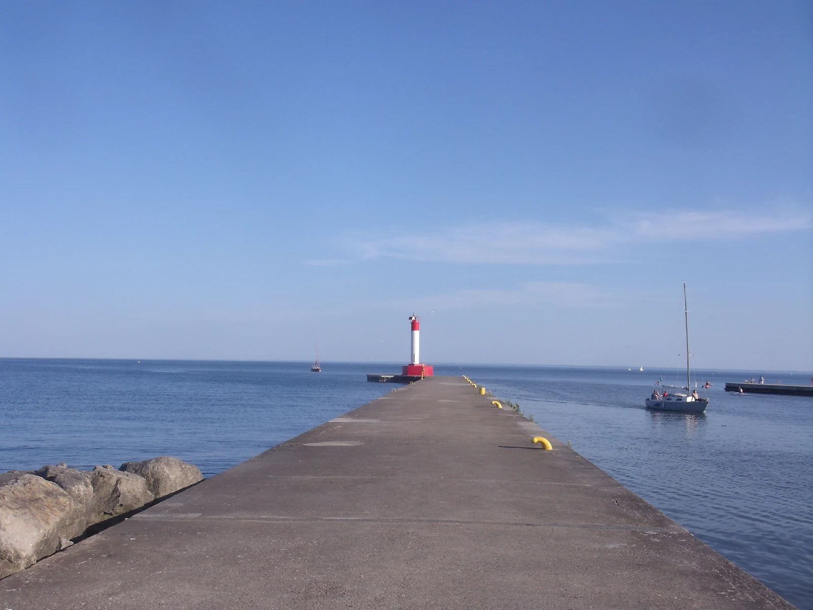 The red-and-white Oakville Harbour lighthouse at the end of the pier on Lake Ontario, downtown Oakville, Ontario